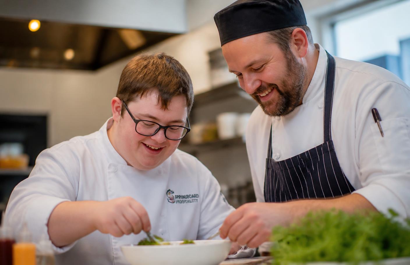 Trainees with disabilities learning culinary skills with a mentor chef